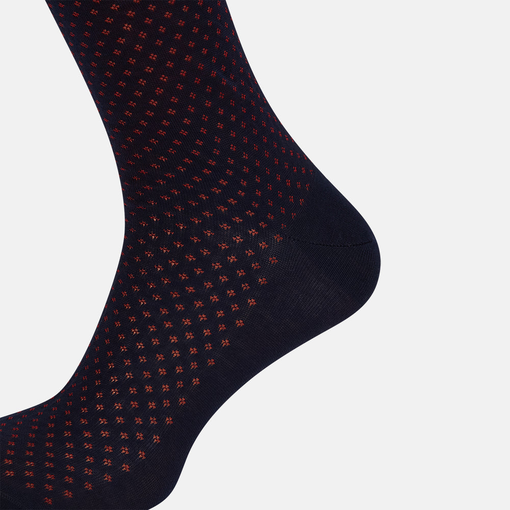 The Turnbull & Asser Navy/Red Motif Long Sock is crafted from mercerised Egyptian cotton, featuring a subtle red and navy diamond pattern with a solid navy cuff, heel, and toe, displayed on a white background.
