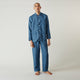 A person stands barefoot against a plain background, wearing the Teal Linen Modern Pyjama Set from Turnbull & Asser.