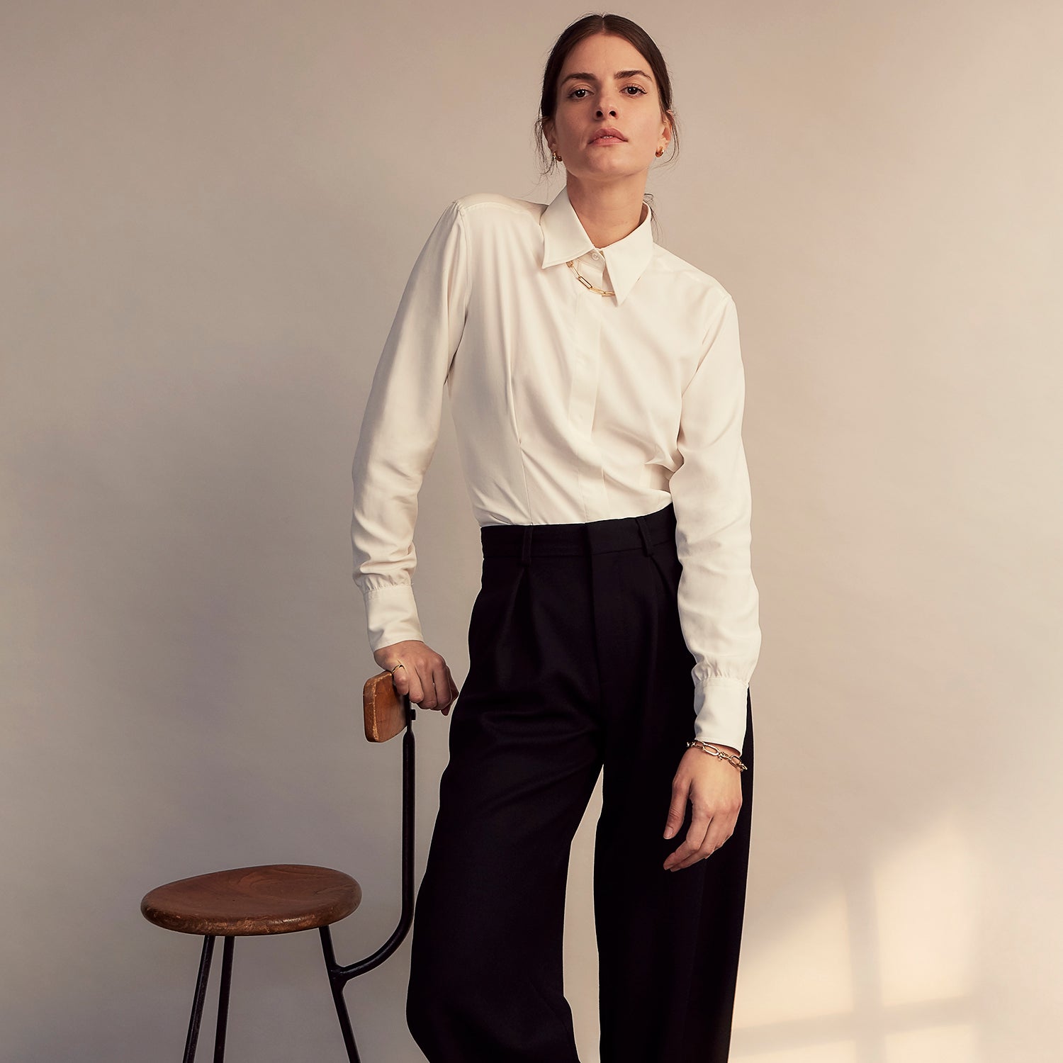 View 10 of product The Cream Silk Tailored Bianca Shirt by Turnbull & Asser features long sleeves, a pointed collar, and curved hem in soft-touch peace silk with a tailored fit. Shown laid flat on a white background.