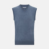 View 1 of product The Avio Blue Cashmere V-neck Vest by Turnbull & Asser is a sleeveless knitwear piece with ribbed hem and armholes, shown against a plain white background.