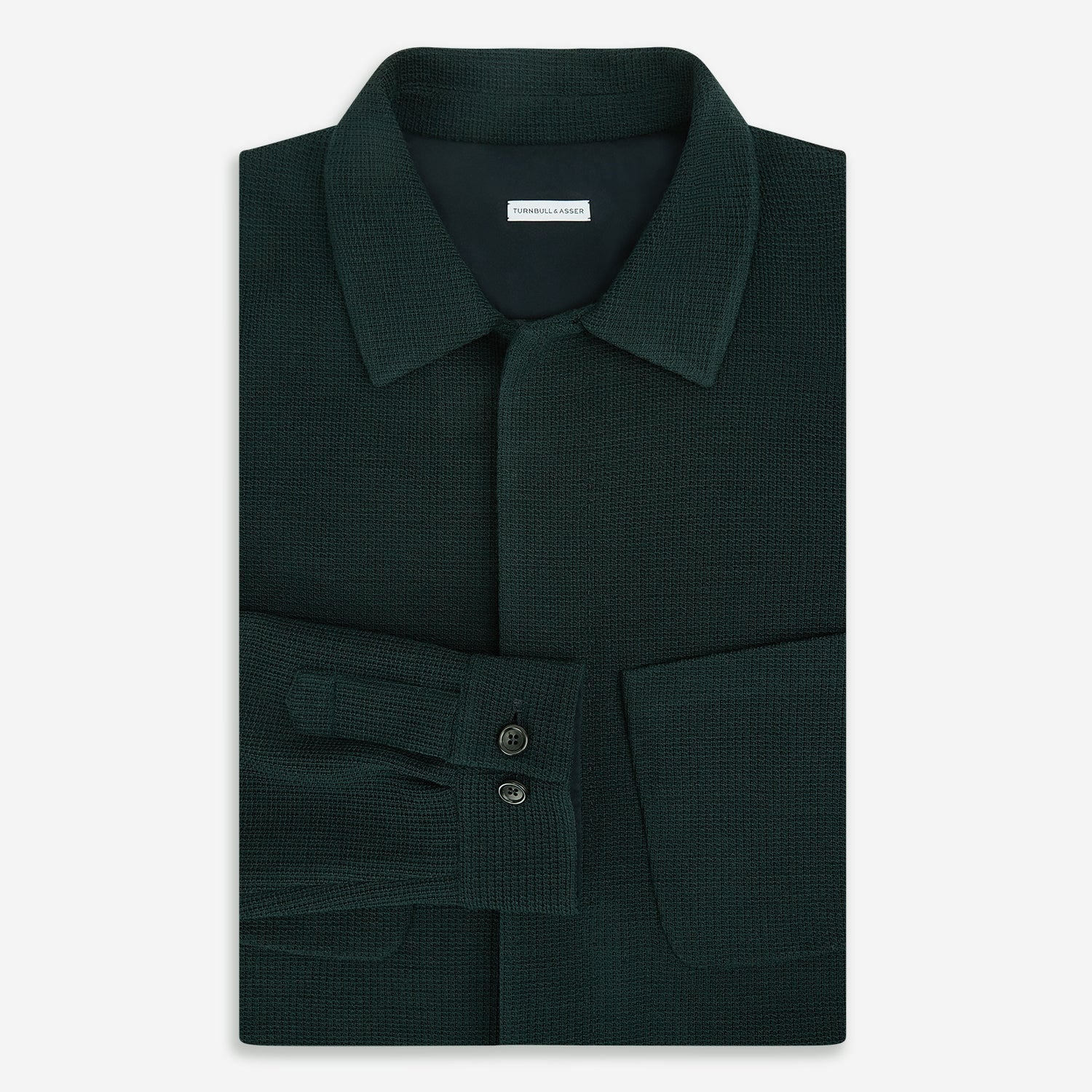 View 5 of product The Forest Green Greenwich Knitted Overshirt by Turnbull & Asser, crafted from Italian wool, features long sleeves, a collar, front buttons, and two chest pockets—one flap, one open—shown on a white background.