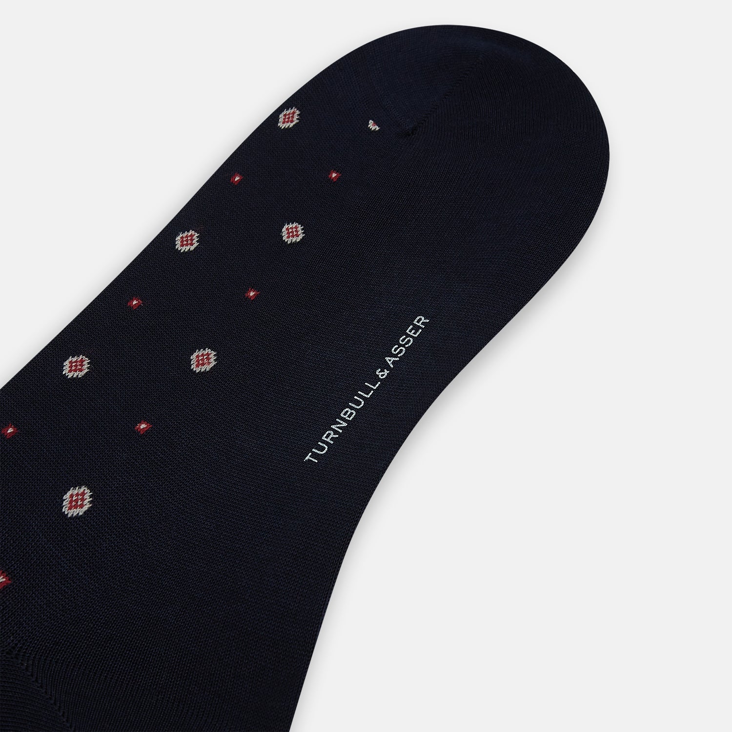 View 3 of product The Turnbull & Asser Midnight Patterned Mid-Length Sock features a ribbed cuff and a design of small white hexagons with red dots, shown here as a single sock on a plain white background.