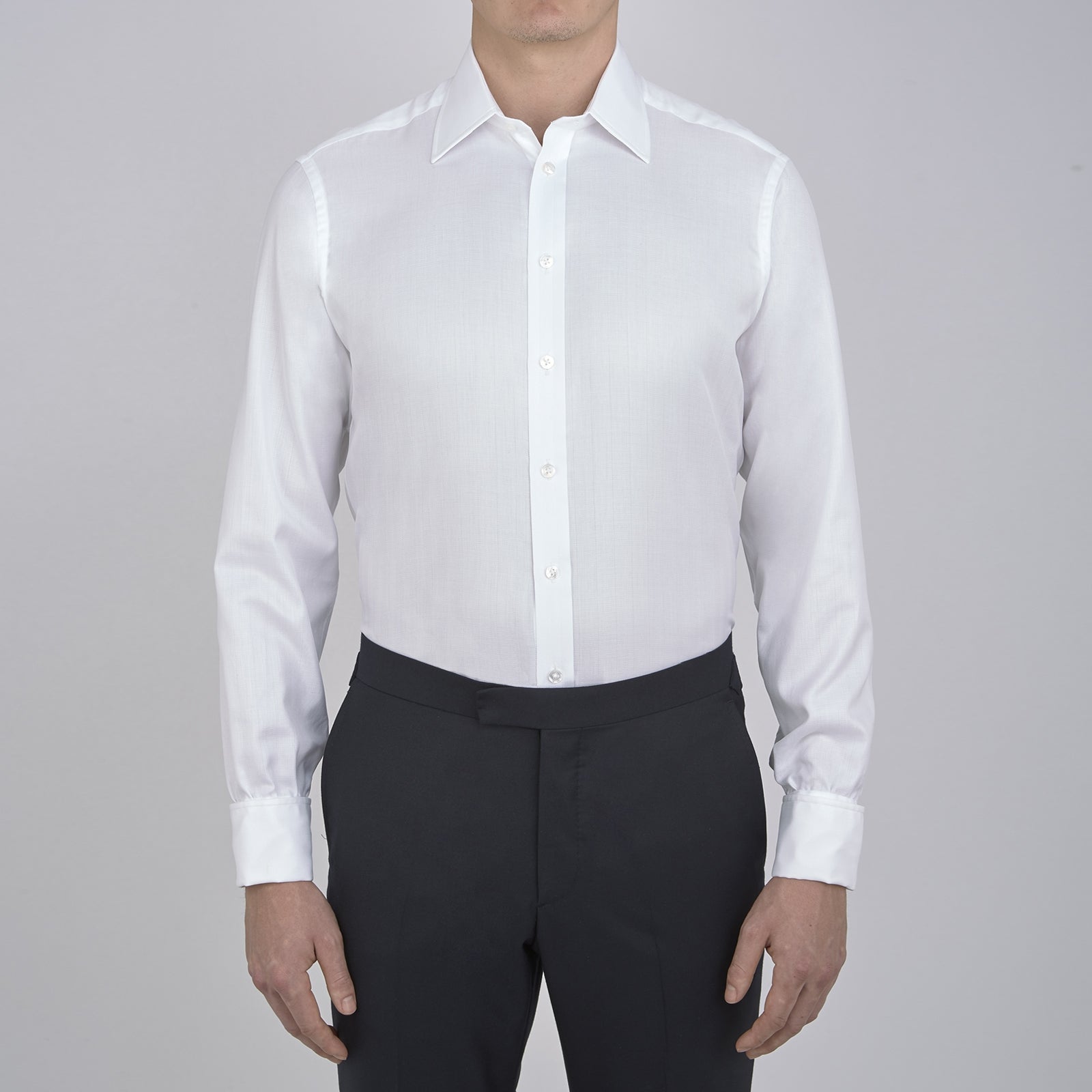 View 2 of product The Turnbull & Asser White Herringbone Superfine Cotton Shirt features a T&A collar, double cuffs, and a visible label inside the collar, shown neatly folded on a light blue background—ideal for minimalist looks or pairing with bold ties.
