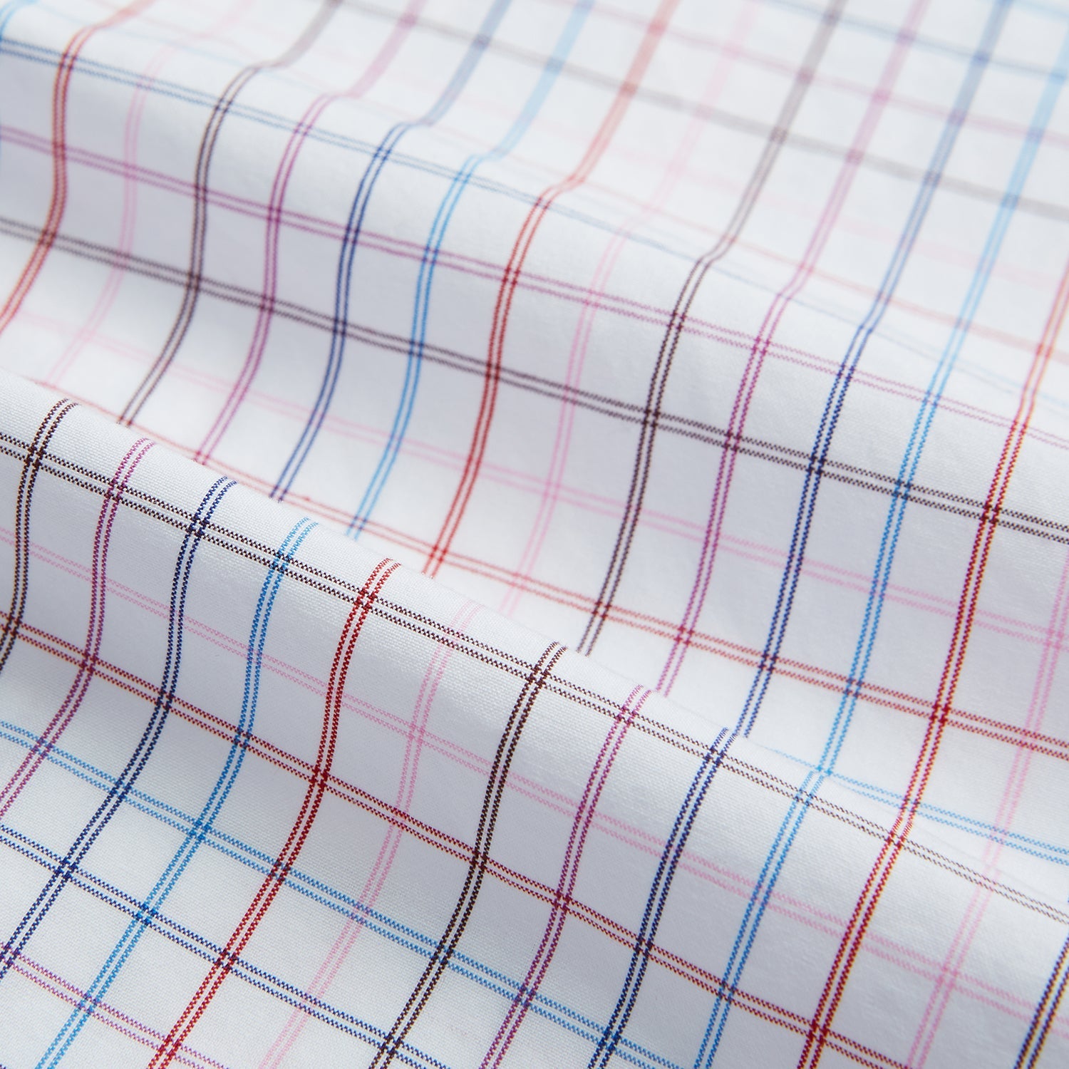 View 4 of product The Turnbull & Asser Hand Rolled Multi Graph Check Handkerchief features a white cotton base with thin red, blue, and purple intersecting lines forming a check pattern, neatly folded with stitched edges for an elegant gentleman's accessory.