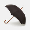 View 1 of product A Black Telescopic Umbrella by Turnbull & Asser with a curved maple handle and shaft, open and angled against a plain white background.