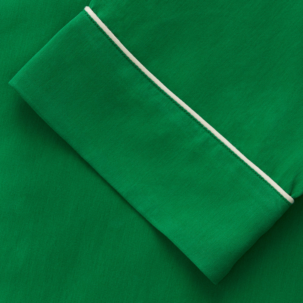 The Turnbull & Asser Green Silk Hyde Pyjamas Set features a long-sleeve button-up top with three pockets and modern fit elastic waistband pants in silk blend, both shown laid flat on a white background.