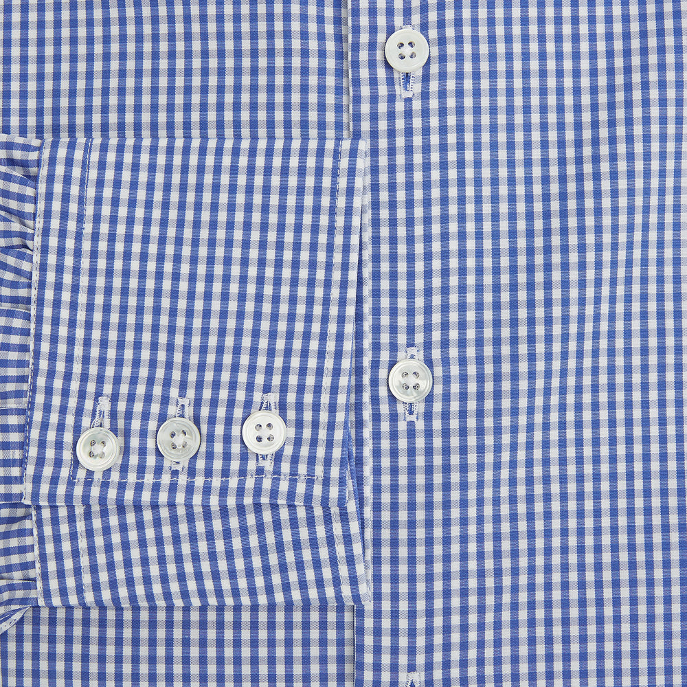 The Turnbull & Asser Blue Grid Check Belgravia Shirt, made from pure cotton with long sleeves, a spread collar, buttoned cuffs, and a blue-and-white check pattern, is laid flat on a white background.