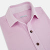 View 2 of product The Turnbull & Asser Pink Polo Shirt is a men's cotton polo with short sleeves, a collar, three dark buttons, and a chest pocket with a button, shown laid flat on a white background.
