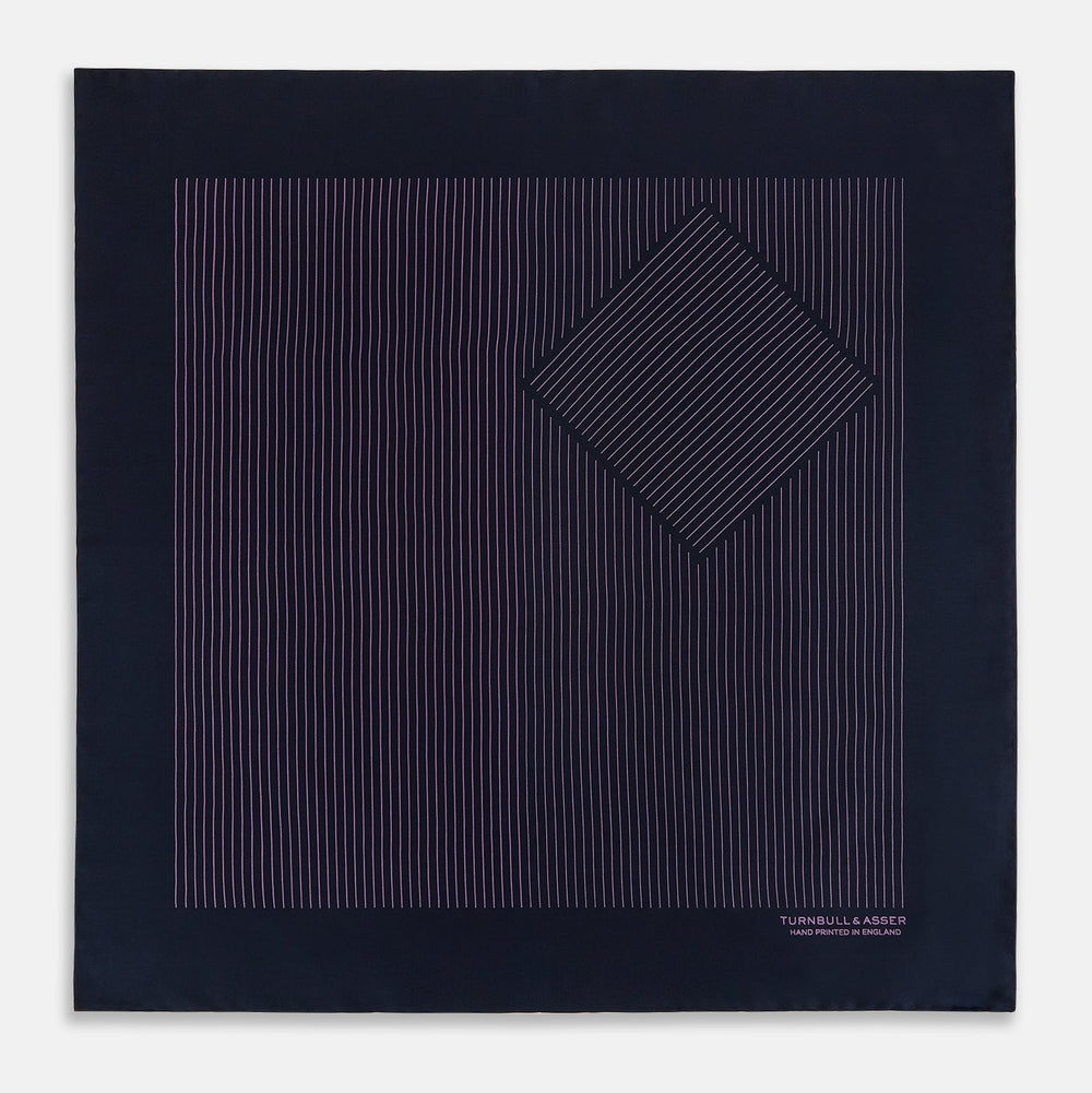 A navy silk pocket square with thin, even purple stripes and hand-rolled edges from Turnbull & Asser, featuring "Turnbull & Asser Hand Printed in England" printed in the corner.