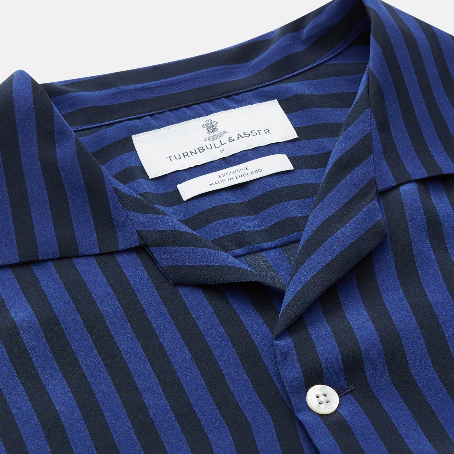View 3 of product The Turnbull & Asser Navy and Blue Multi Stripe Silk Holiday Fit Winnington Shirt features white buttons, a notched collar, and a chest pocket, shown laid flat on a white background.