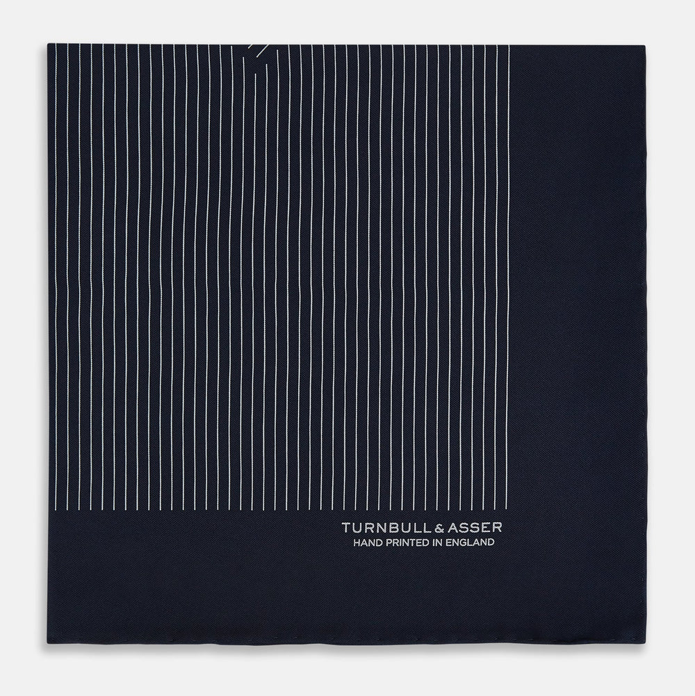 A Navy and Grey Stripe Silk Pocket Square by Turnbull & Asser, featuring hand-rolled edges and brand text in the corner. One corner is folded to show the reverse side.