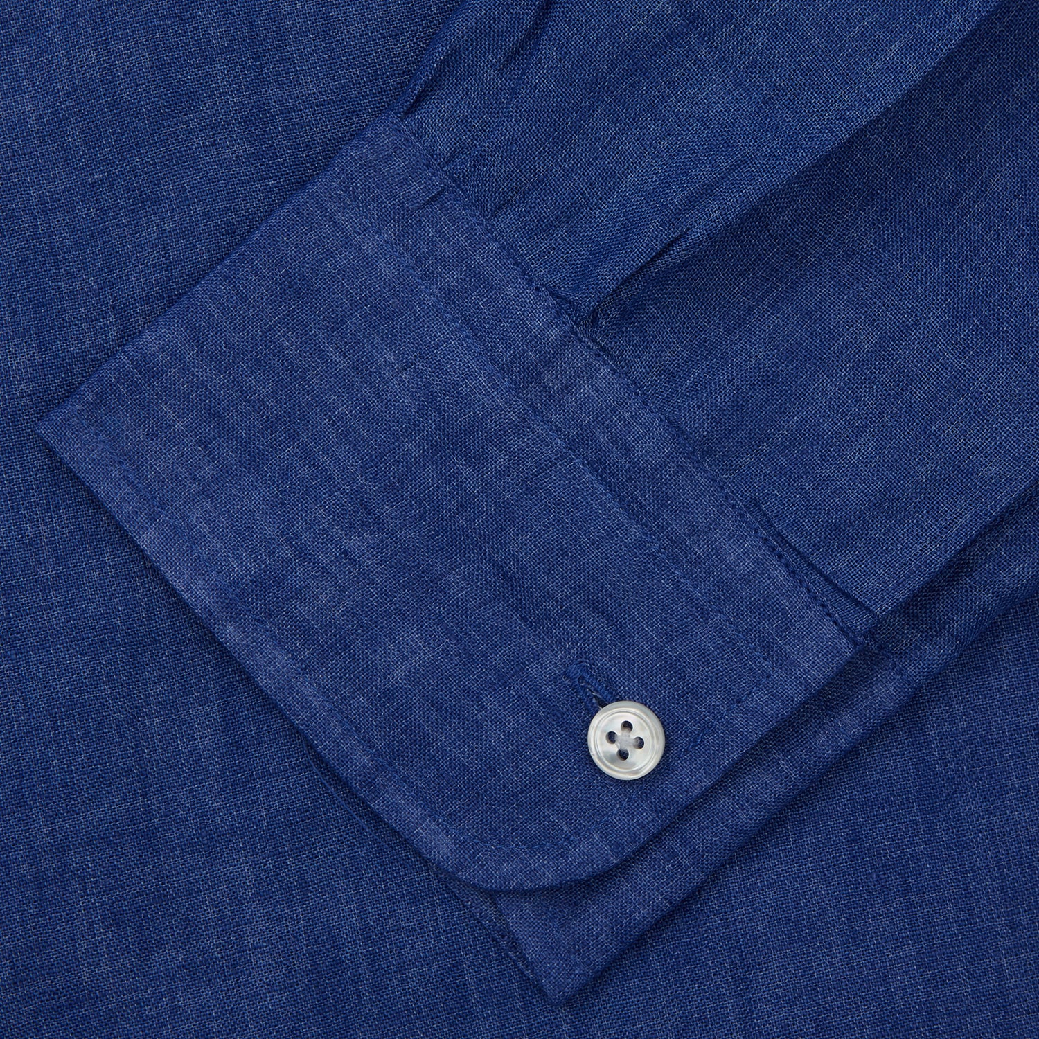 View 6 of product A man faces forward with a neutral expression, hands in his pockets, wearing the Turnbull & Asser Plain Indigo Linen Weekend Fit Shirt with a stand collar, styled with dark pants and black shoes against a plain light background.