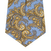View 4 of product The Turnbull & Asser GGT92000 3062 06 OS is a rolled-up necktie with an intricate blue and yellow paisley pattern on a light blue background—a stylish accessory for any wardrobe.