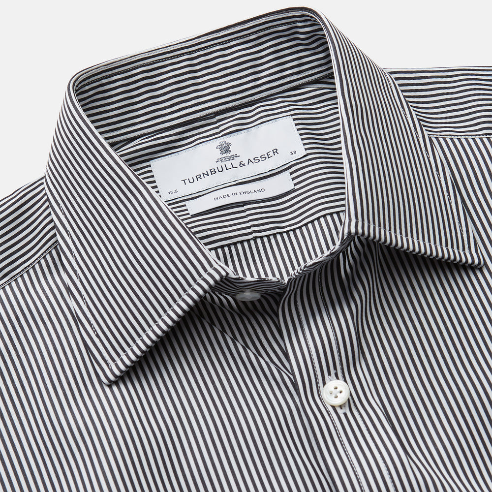 The Turnbull & Asser Black Candy Stripe Cotton Regular Fit Mayfair Shirt features long sleeves, a T&A collar, white buttons, and thin black stripes, displayed on a plain white background.