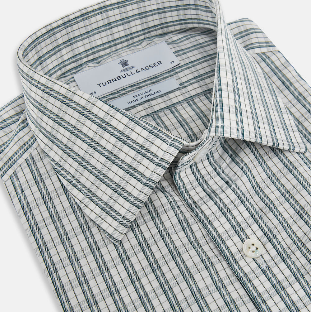 The Turnbull & Asser Forest Green Multi Check Mayfair Shirt is a long-sleeve button-up crafted from premium Italian cotton, featuring a blue and forest green check on white, with a pointed collar and buttoned cuffs.