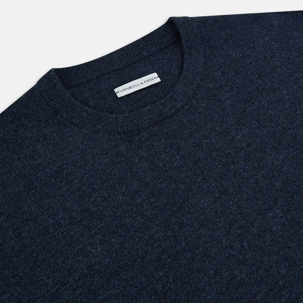 The Turnbull & Asser Midnight Blue Cashmere Round Neck Jumper, featuring long sleeves and ribbed trims, is shown against a light grey background.