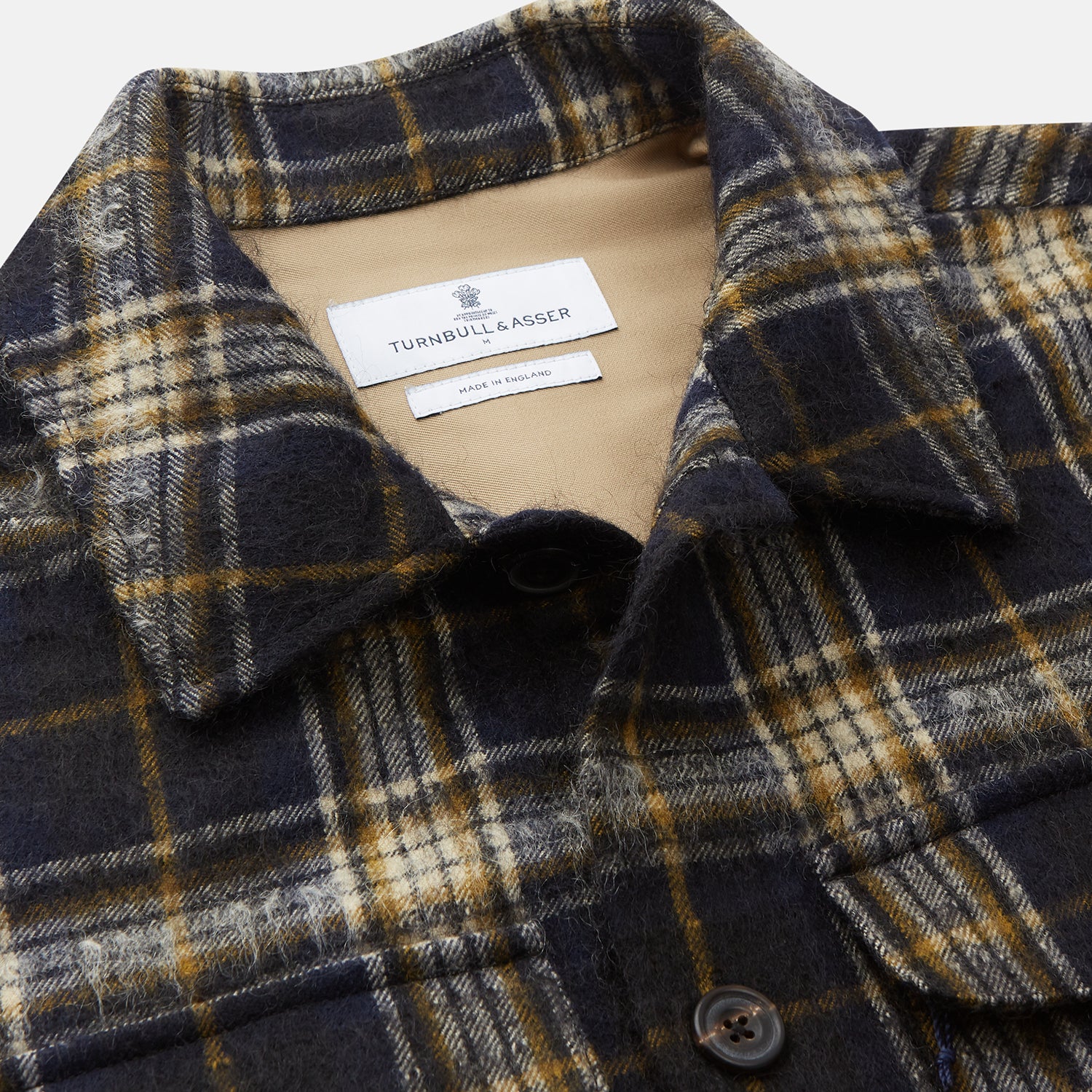 View 2 of product The Turnbull & Asser Navy and Beige Check Wool and Mohair Blend Somerset Overshirt, featuring long sleeves, two chest pockets, and a classic collar, is laid flat on a white background.