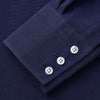 View 4 of product The Turnbull & Asser Blue Soft-touch Silk Lauren Shirt is a navy, long-sleeve button-up with an Igret stand collar, white buttons, curved hem, relaxed fit, and elongated body for a modern look, shown laid flat on a white background.