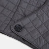 View 5 of product The Turnbull & Asser Shadow Grey Quilted Hood with Neck Warmer features a button closure, inspired by quilted jacket hoods, and is displayed on a plain white background.