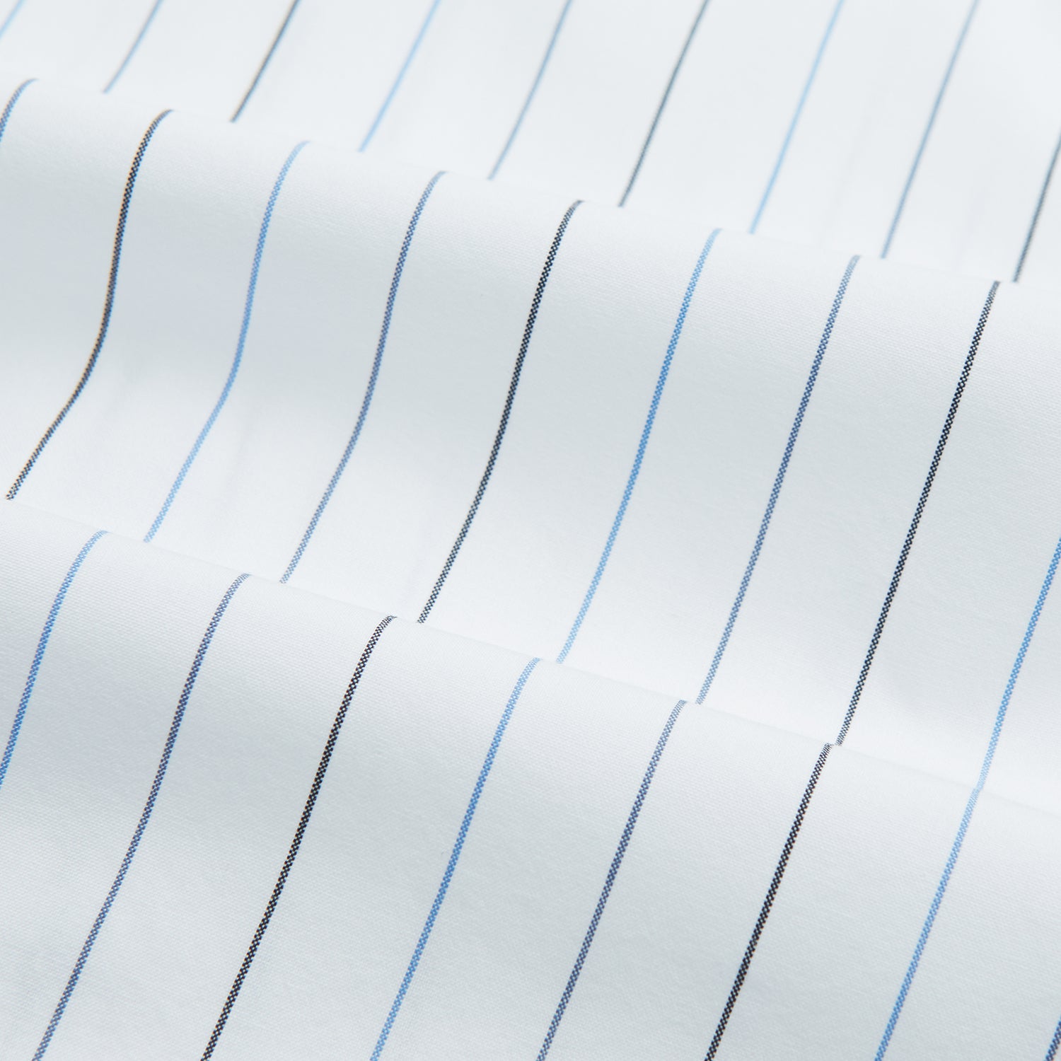 View 6 of product The Blue Wide Pinstripe Mayfair Shirt by Turnbull & Asser is a contemporary long-sleeve button-down with a collar, crafted from white fabric with bold vertical blue pinstripes. It is displayed neatly on a plain white background.