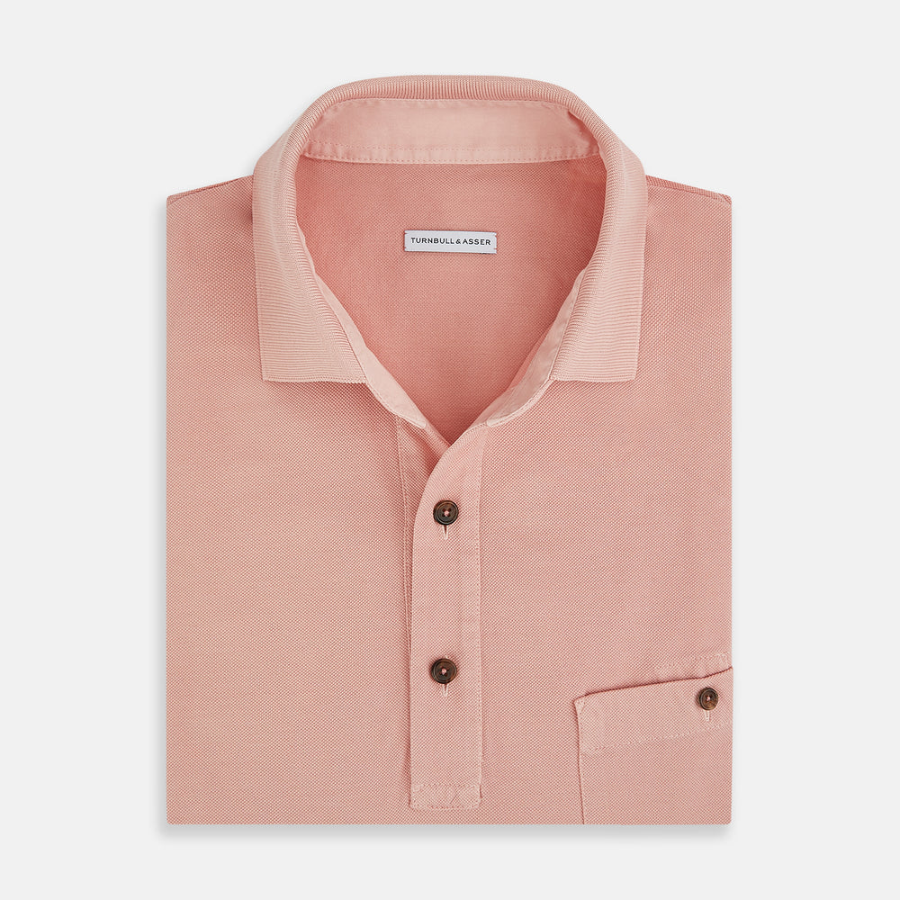 The Orange Polo Shirt by Turnbull & Asser features short sleeves, a collar, three-button placket, and a small buttoned chest pocket in soft cotton jersey—timeless men's style laid flat on a white background.
