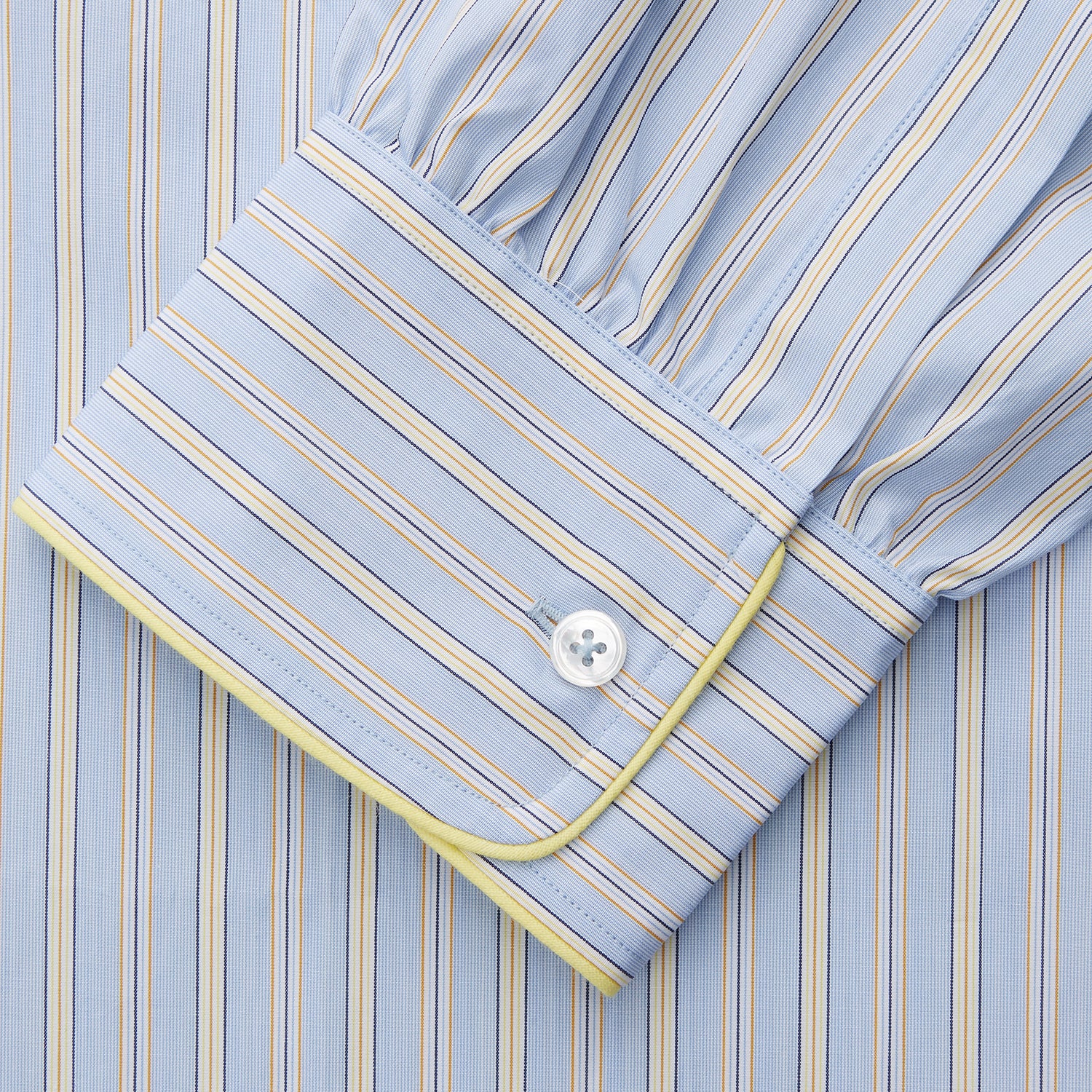 View 3 of product The Turnbull & Asser Blue and Yellow Stripe Poplin Cotton Nightshirt features light blue and yellow vertical stripes, long sleeves, a classic collar, single chest pocket, rounded hem, and is displayed flat on a white background.