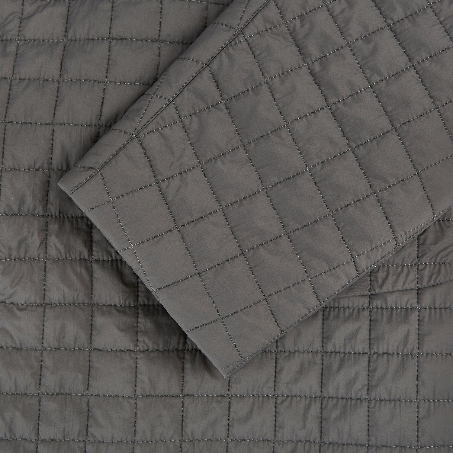 View 4 of product The Fulham Shadow Grey Single-Breasted Quilted Blazer by Turnbull & Asser features a checkered pattern, notched lapel, three front buttons, chest pocket, and two flap pockets—ideal for formal wear on a plain white background.