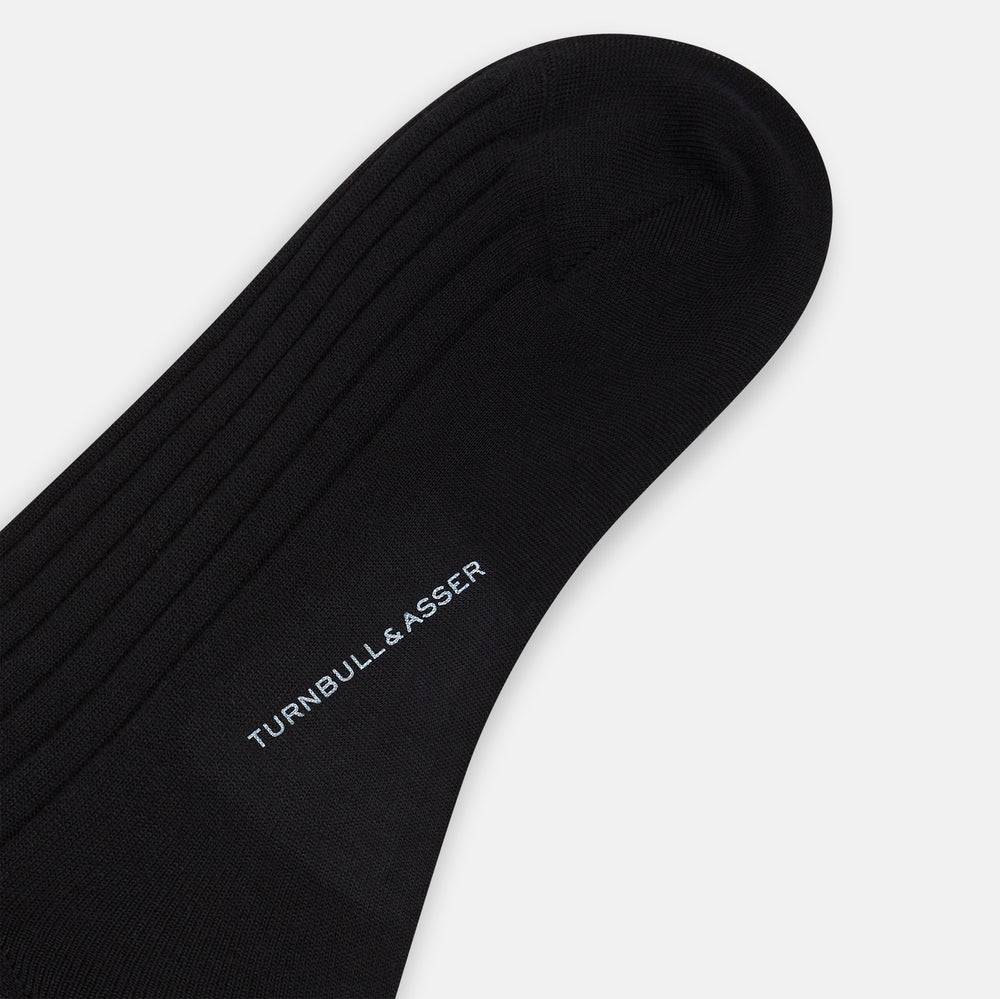 A single Turnbull & Asser Black Wool Mid-Length Sock is displayed on a plain white background, angled to reveal its full length from toe to cuff.