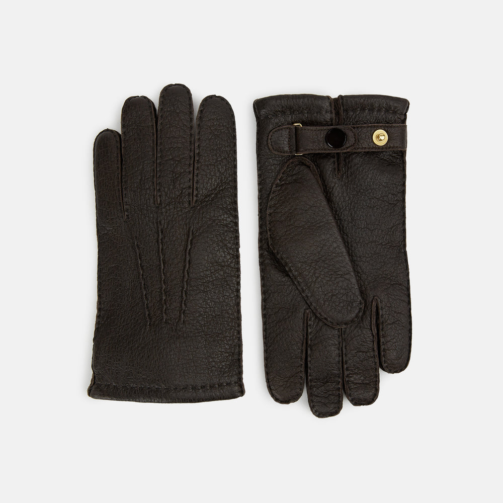 Turnbull & Asser's Dark Chocolate Cashmere-Lined Peccary Leather Gloves feature visible stitching, a buttoned strap on the palm side, and luxurious Scottish cashmere lining for superior comfort.