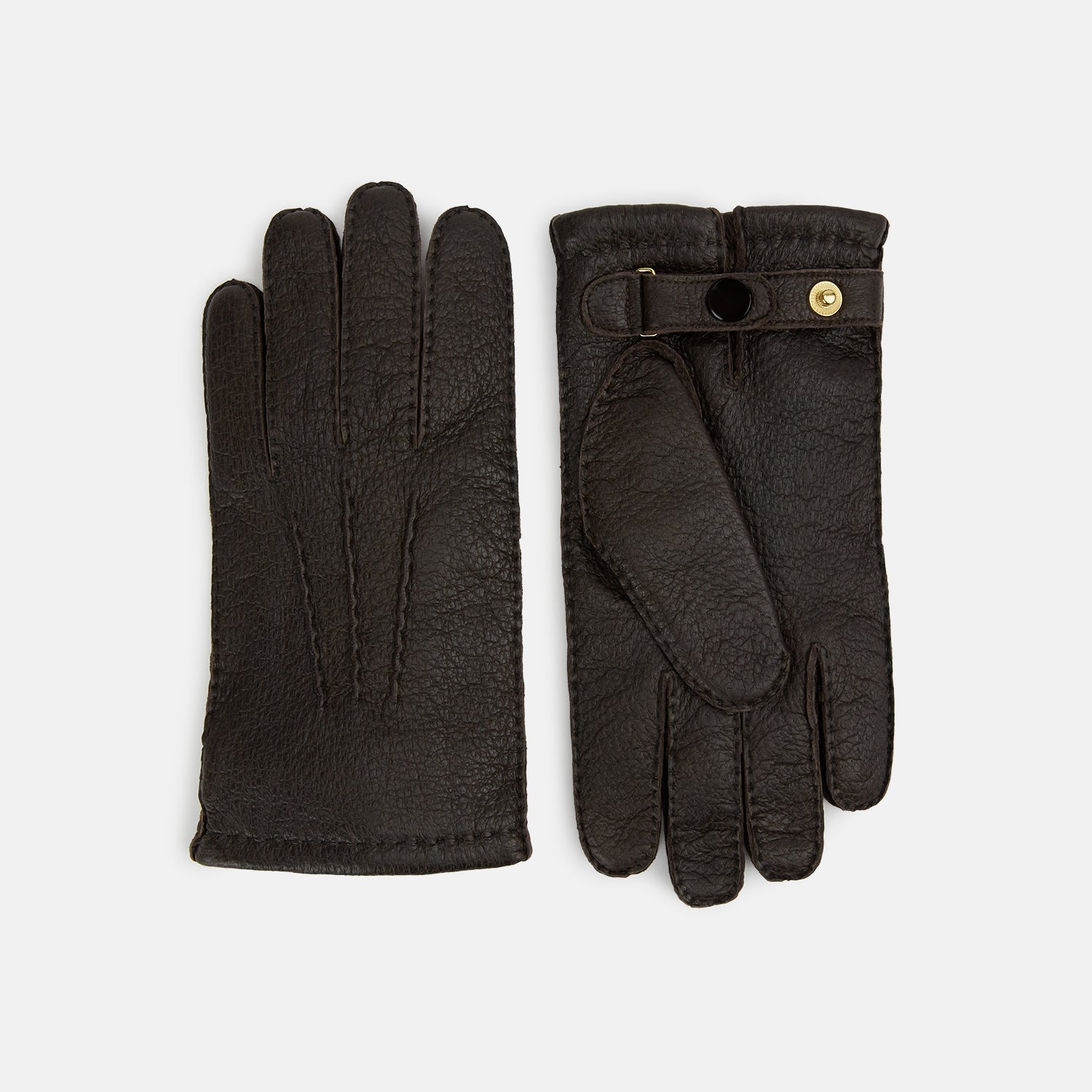 View 1 of product Turnbull & Asser's Dark Chocolate Cashmere-Lined Peccary Leather Gloves feature visible stitching, a buttoned strap on the palm side, and luxurious Scottish cashmere lining for superior comfort.