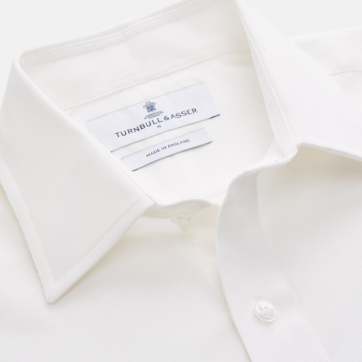 View 3 of product The White Cotton Weekend Fit Langston Shirt by Turnbull & Asser, with a Derby collar, long sleeves, and two button-flap chest pockets, is shown laid flat on a white background.