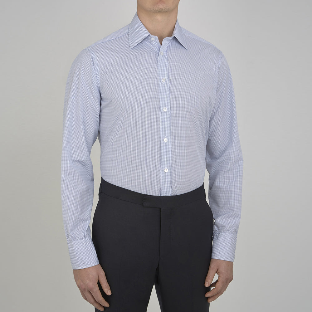 A neatly folded Turnbull & Asser Blue Grid Check Shirt features a T&A collar, 3-button cuffs, white buttons, and subtle British style. The blue and white check cotton design displays the brand label inside the collar.