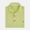 View 4 of product The Turnbull & Asser Lime Green Polo Shirt features a cotton jersey build, short sleeves, a collar, three brown buttons on the placket, and a chest pocket with a button. Shirt shown laid flat on a white background.