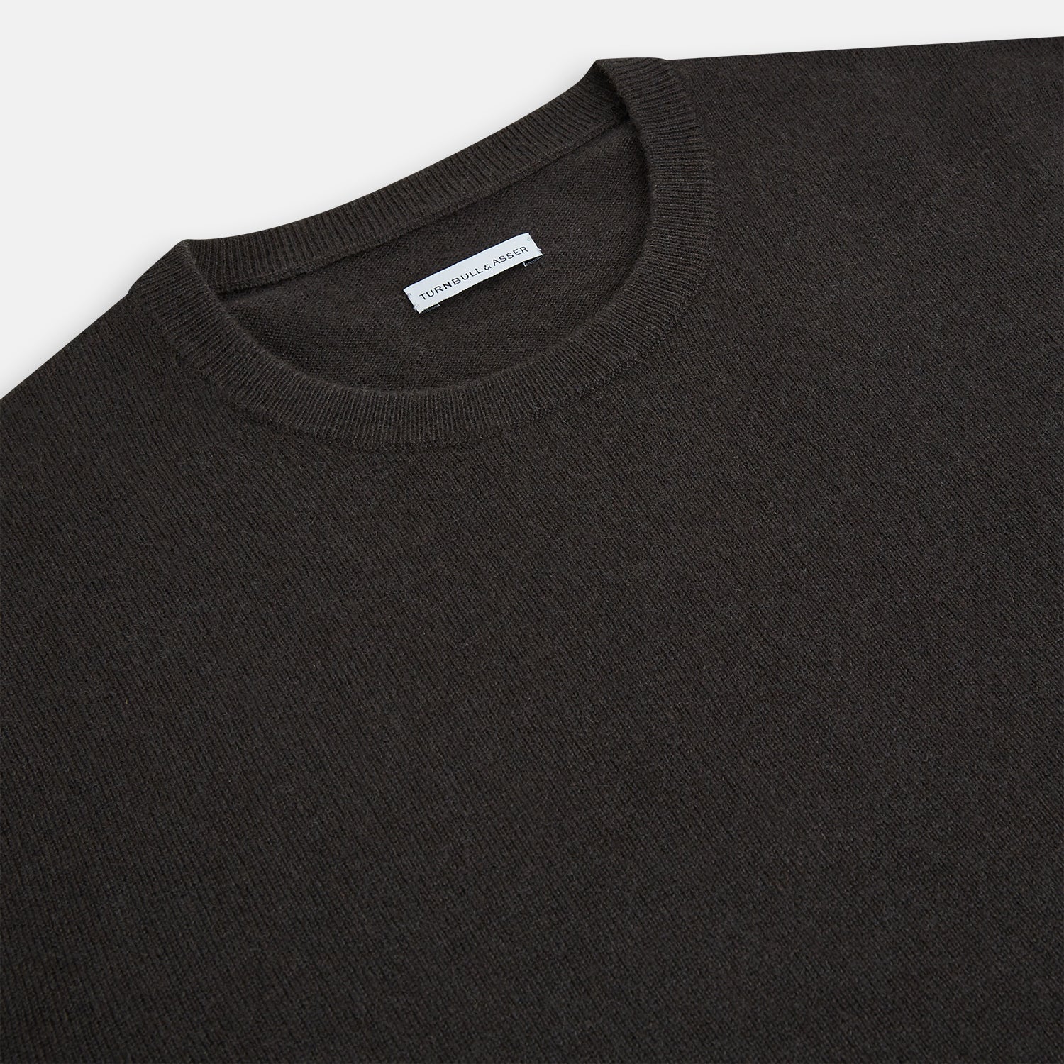 View 2 of product A plain, long-sleeved brown cashmere round neck jumper by Turnbull & Asser displayed on a white background. This men’s knitwear features ribbed cuffs, hem, and neckline with a relaxed fit and no visible patterns or logos.