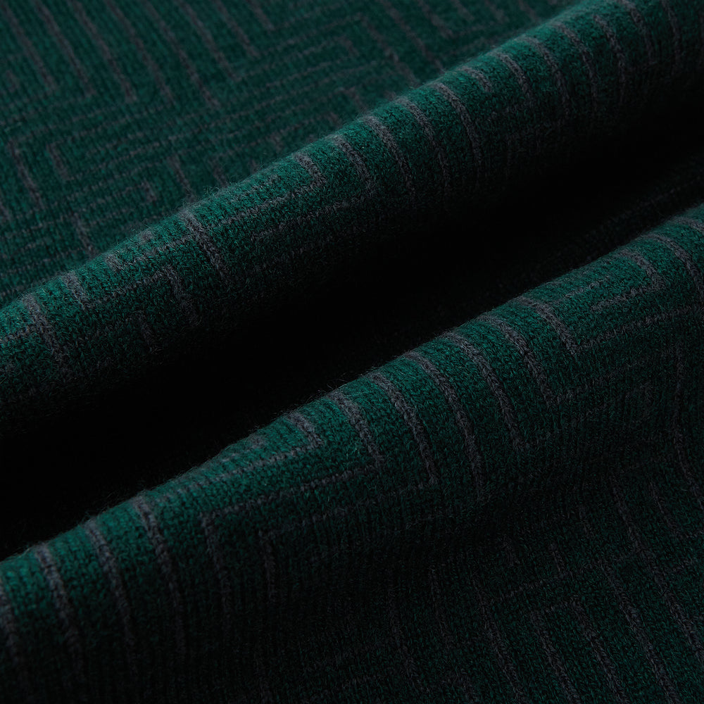 The Turnbull & Asser Forest Green and Charcoal Fretwork Cashmere Knitted Scarf, featuring a subtle geometric pattern, is neatly folded and knotted against a plain white background.