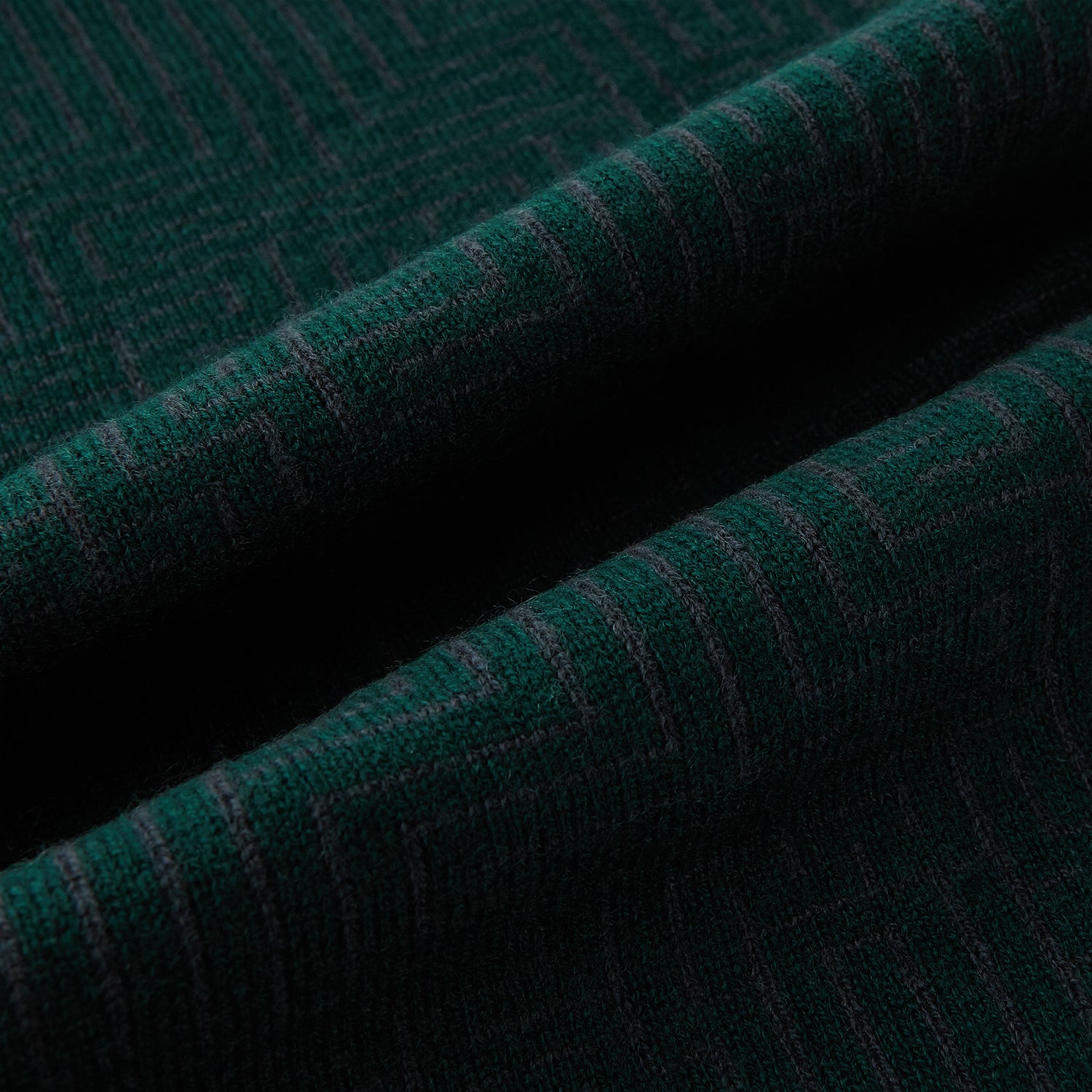 View 3 of product The Turnbull & Asser Forest Green and Charcoal Fretwork Cashmere Knitted Scarf, featuring a subtle geometric pattern, is neatly folded and knotted against a plain white background.