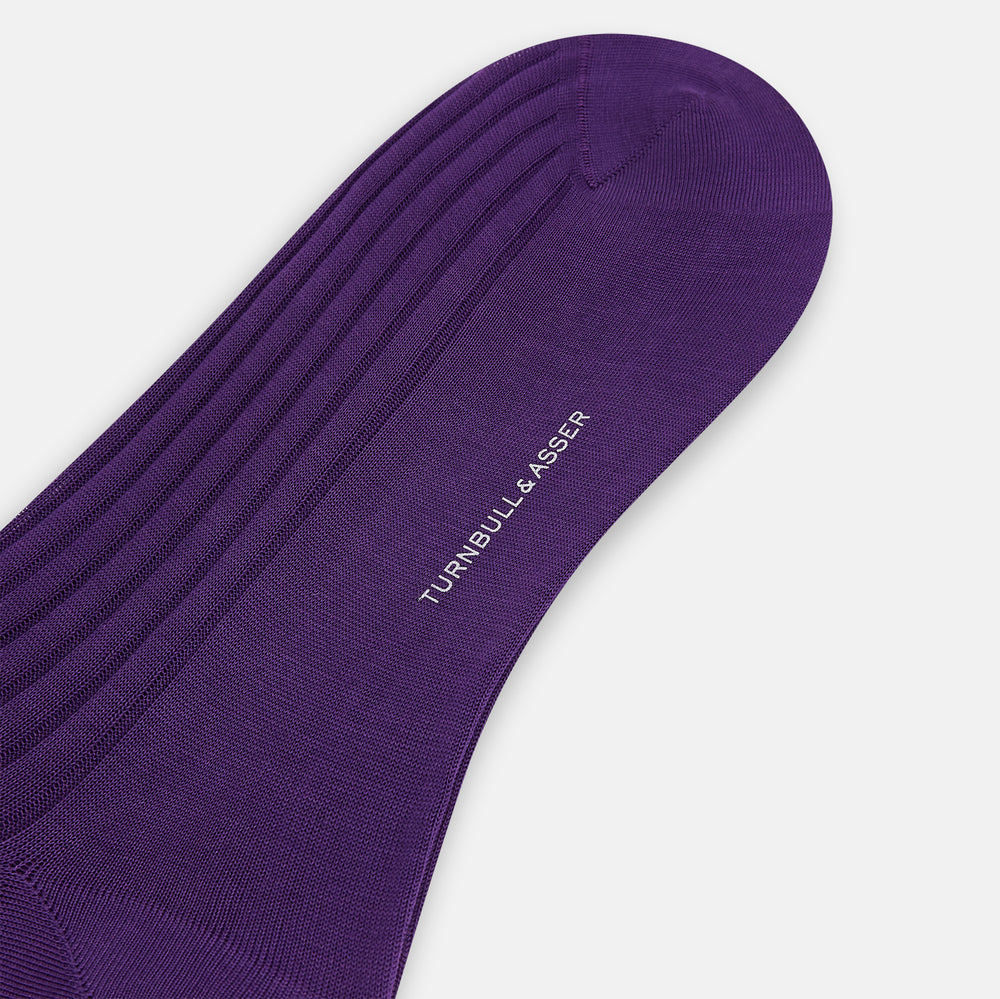 A single Purple Mid-Length Sock by Turnbull & Asser stands upright against a white background, highlighting its refined ribbed texture in solid dark purple mercerised Egyptian cotton.