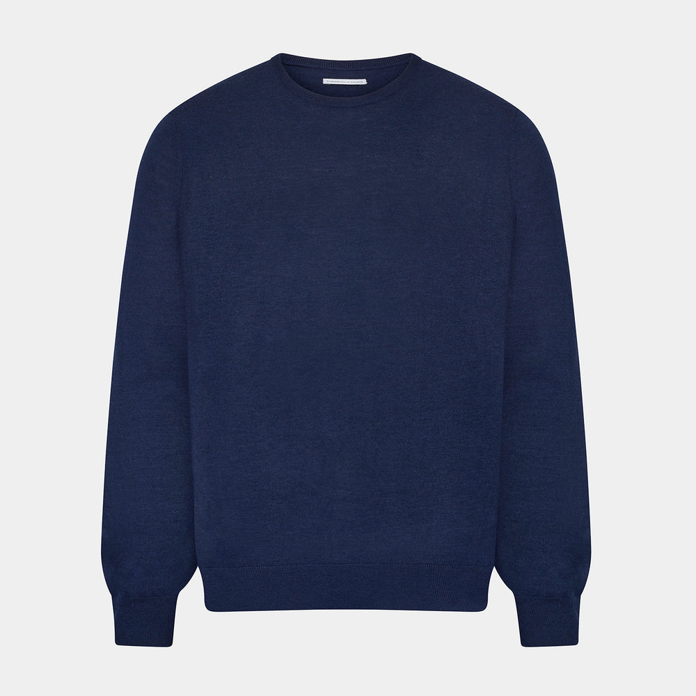 The Turnbull & Asser Navy Merino Round Neck Jumper is shown against a light gray background, featuring a classic long-sleeve design with ribbed cuffs, hem, and neckline for timeless style.