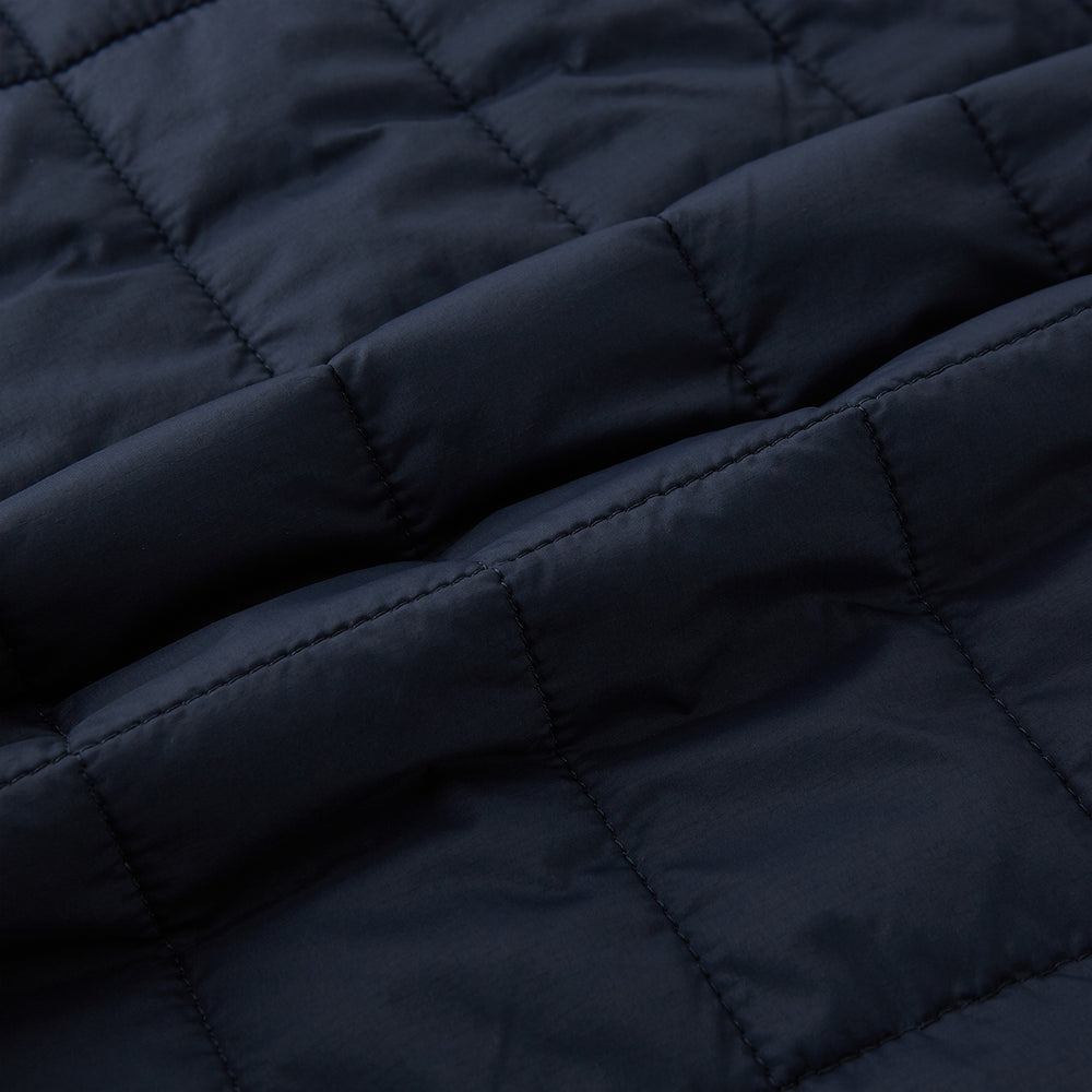 The Turnbull & Asser Navy Quilted Gilet is sleeveless and lightweight, with a front zipper, zippered side pockets, chest pocket, and rounded hem—ideal for versatile layering. Shown on a plain white background.