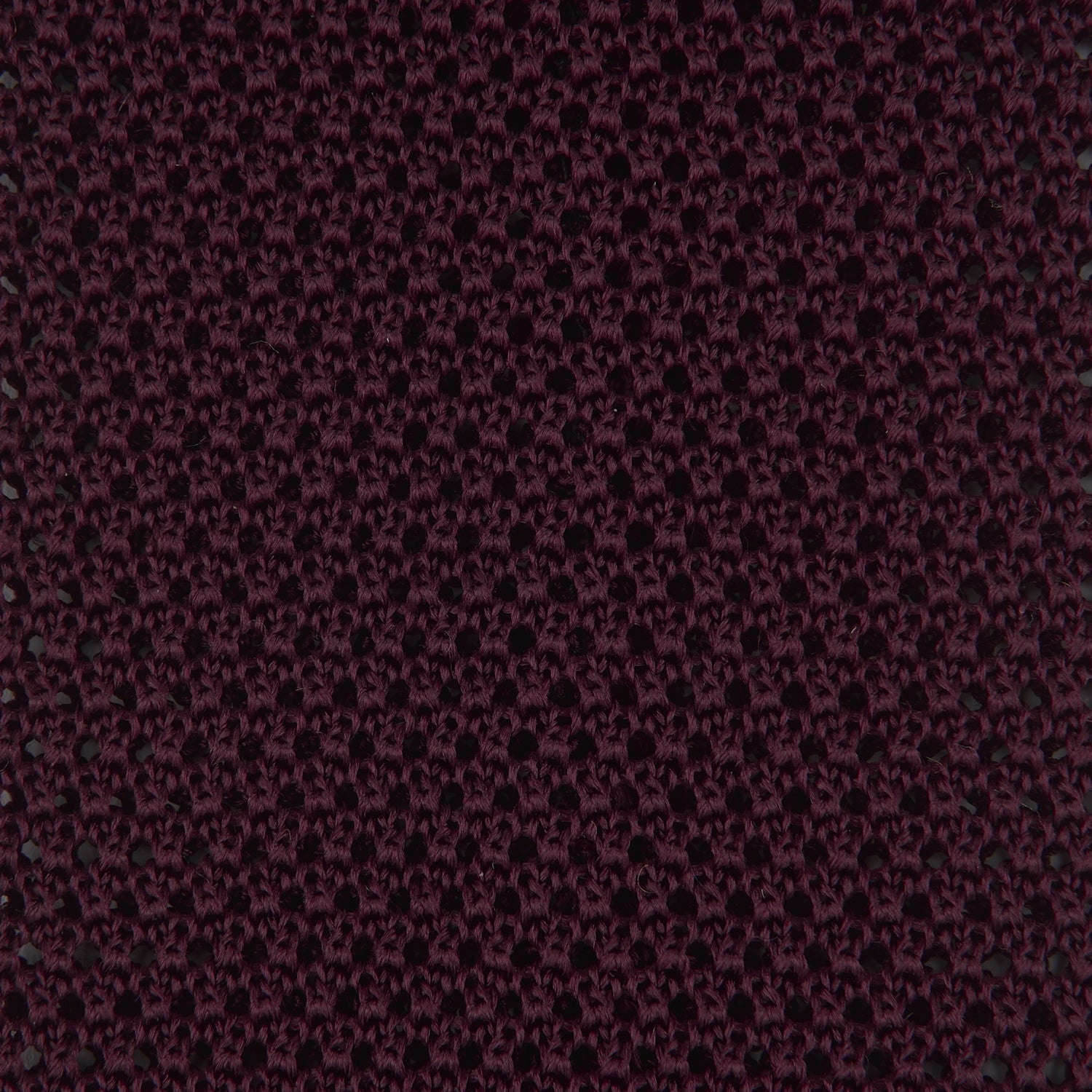 View 3 of product The Turnbull & Asser MTIE011-ZAI003 TIES 7.5CM is a plain burgundy tie shown rolled on a white background, featuring straight edges and textured knit—ideal for the modern gentleman’s versatile wardrobe.