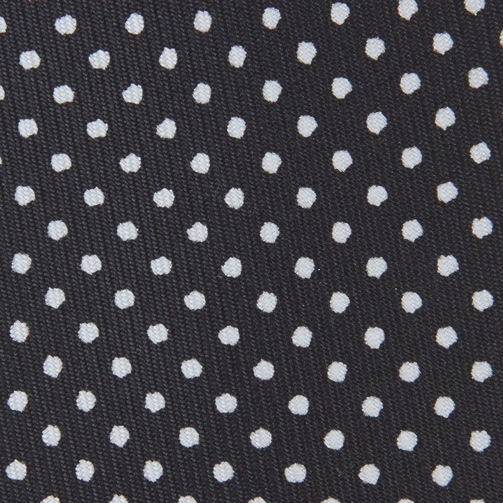 View 3 of product The Turnbull & Asser Black and White Spot Printed Silk Tie, shown neatly rolled on a plain white background, is an essential accessory to elevate any smart attire.