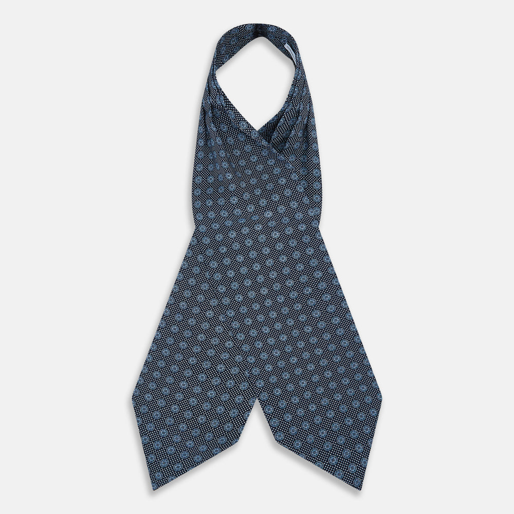 The Turnbull & Asser Navy Medallion Silk Cravat features a white geometric and circular pattern, its classic design and rich navy hue echoing refined British elegance.
