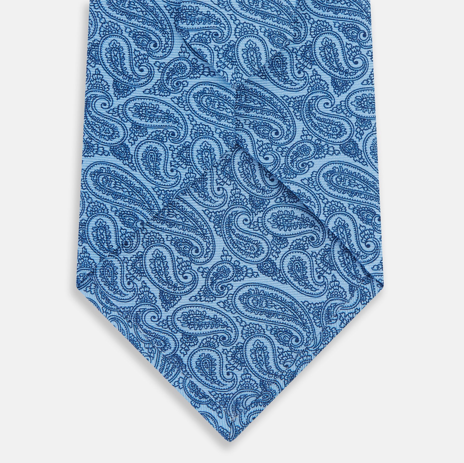 View 3 of product The Blue Paisley Silk Tie by Turnbull & Asser is crafted from fine English silk and features an intricate blue paisley pattern on a crisp white background—an elegant choice for any formal occasion.