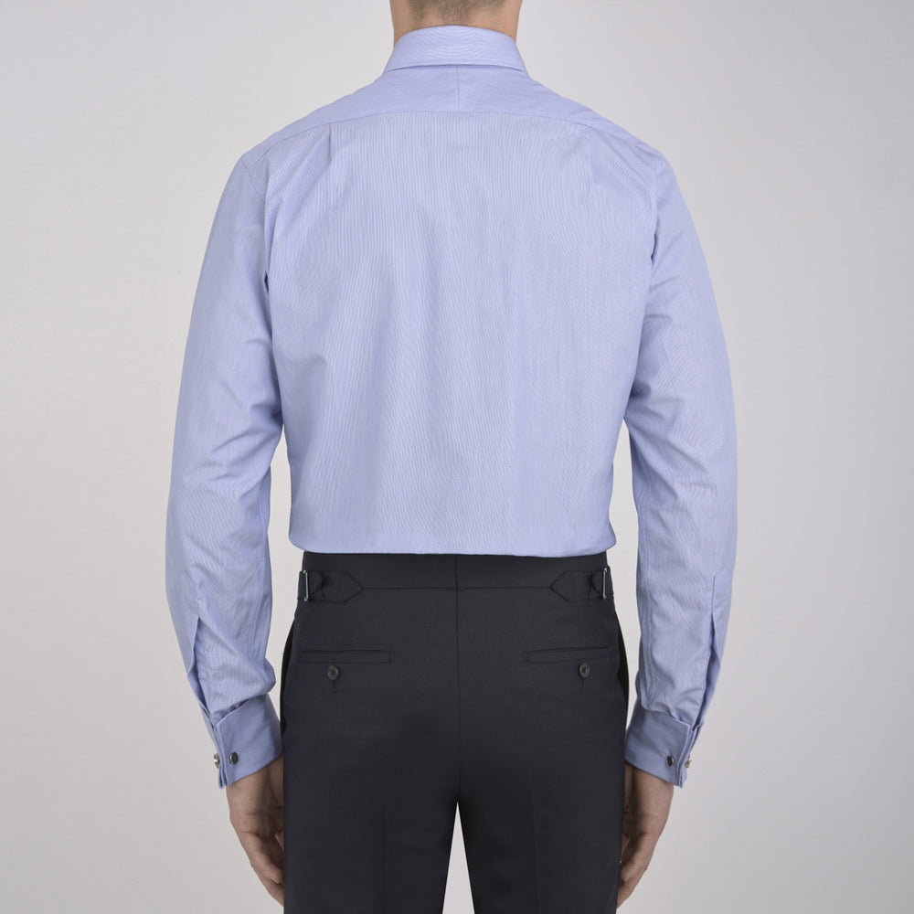 The Turnbull & Asser Blue Hairline Stripe Shirt features a T&A collar, 3-button cuffs, and white buttons. Made from light blue cotton with subtle stripes, it’s neatly folded with the label visible inside the collar on a plain white background.