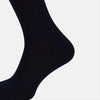 View 4 of product A single Navy Thick Knit Mid-Length Sock by Turnbull & Asser is shown in side profile against a plain white background, with the toe pointing left and the cuff at the top.