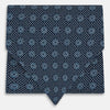 View 1 of product The Turnbull & Asser Navy Medallion Silk Cravat features a white geometric and circular pattern, its classic design and rich navy hue echoing refined British elegance.