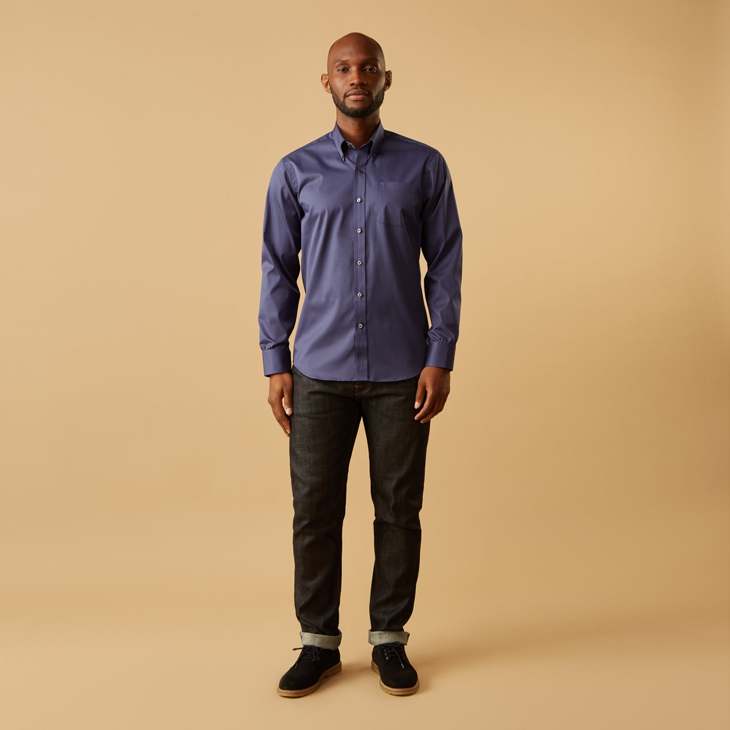 View 6 of product The Blue Piece Dyed Weekend Fit Suffolk Shirt by Turnbull & Asser features a button-down Dorset collar, chest pocket, white buttons, and long sleeves in classic navy, laid flat against a white background.