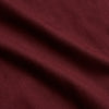 View 4 of product A person stands indoors by a window, wearing the Turnbull & Asser Burgundy Cotton-Cashmere Kimono Gown over striped pajamas, with matching slippers, next to cream curtains and a wooden chair against a pale wall.