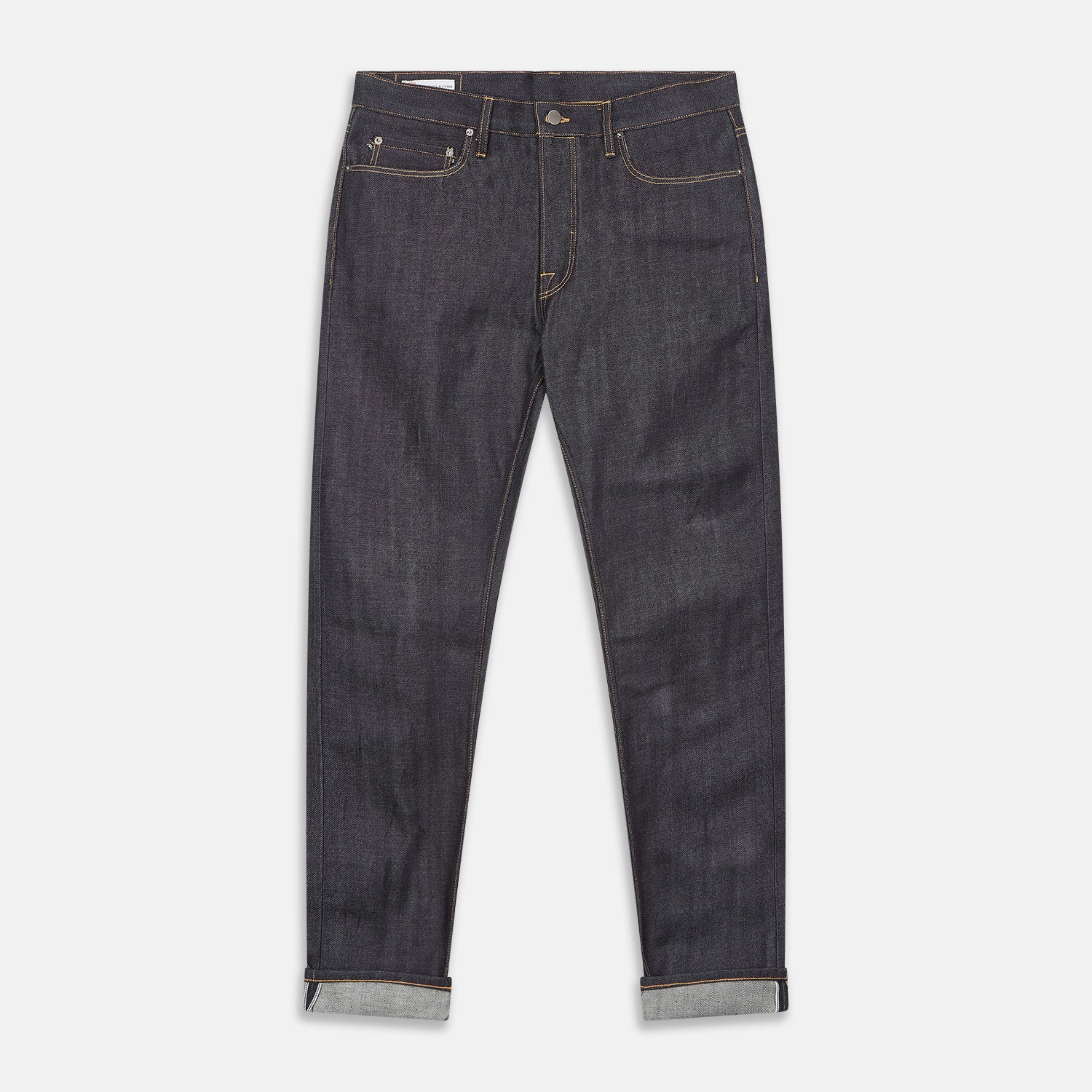 View 1 of product A pair of Turnbull & Asser Indigo Japanese Selvedge Denim Jeans in dark blue with rolled-up cuffs, yellow stitching, five pockets, and a button fly, laid flat on a white background.