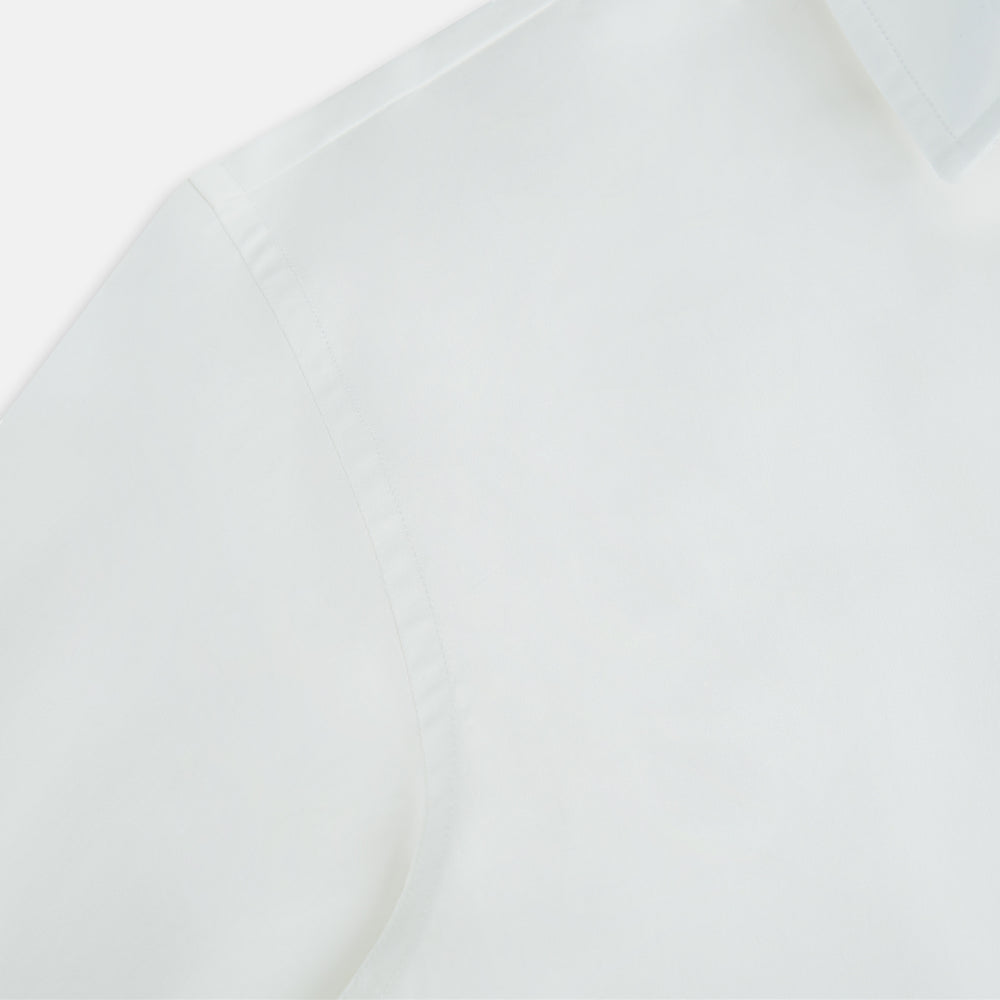 The Turnbull & Asser Plain White Windsor Shirt features a Turnbull open collar, 3-button cuffs, and relaxed fit—exemplifying British craftsmanship. Displayed on a white background.